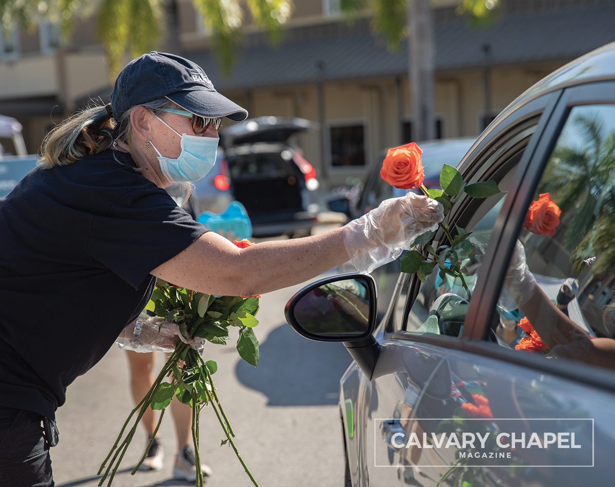 handing a rose to a lady in car