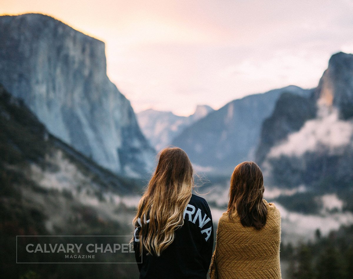 Two women standing with mountains