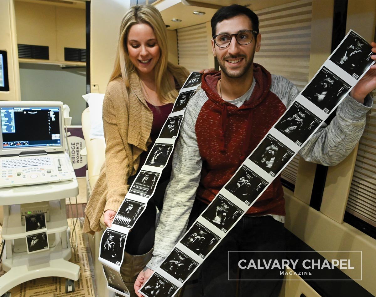 Couple holding their ultrasound photos