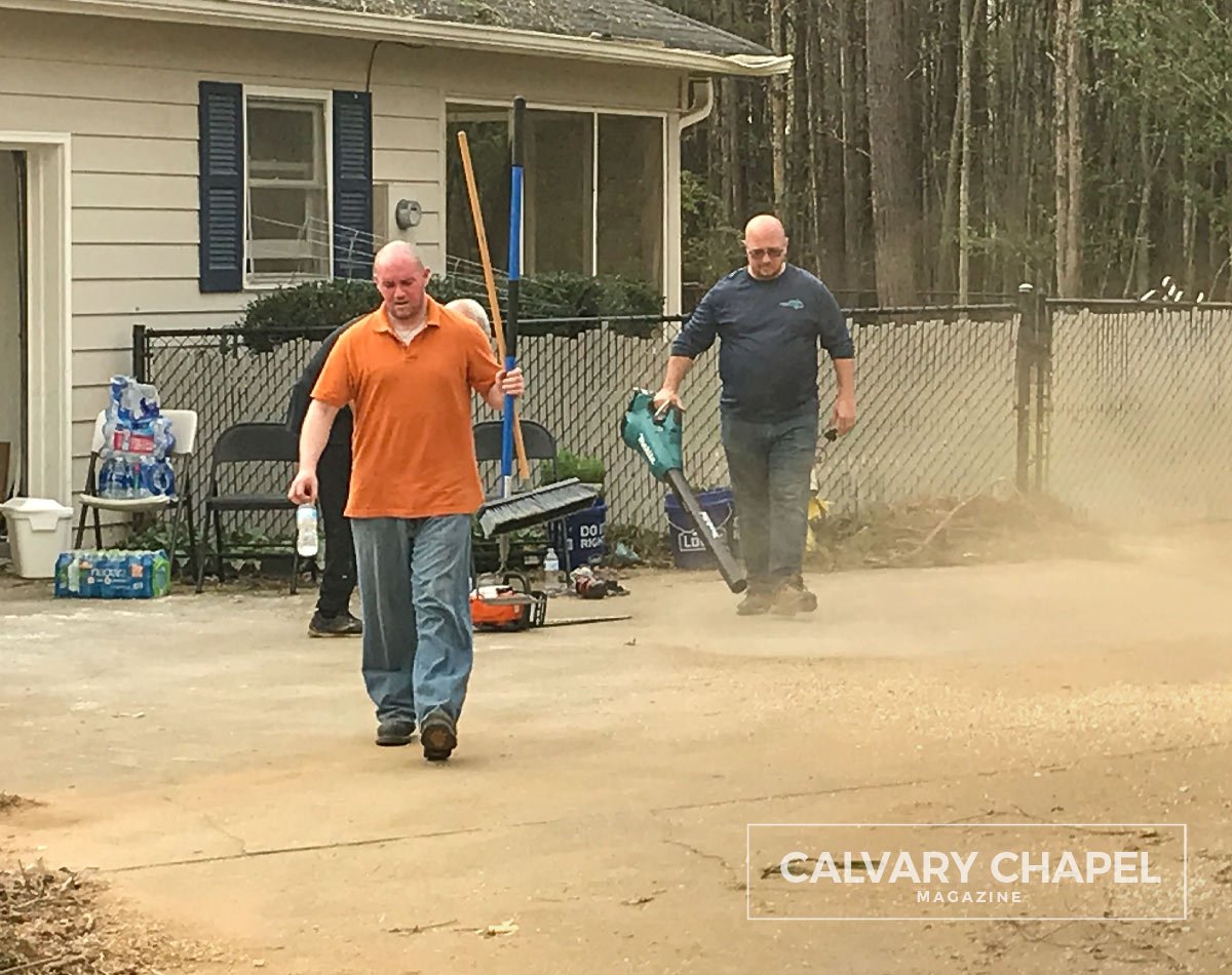 Men cleaning up in dusty road