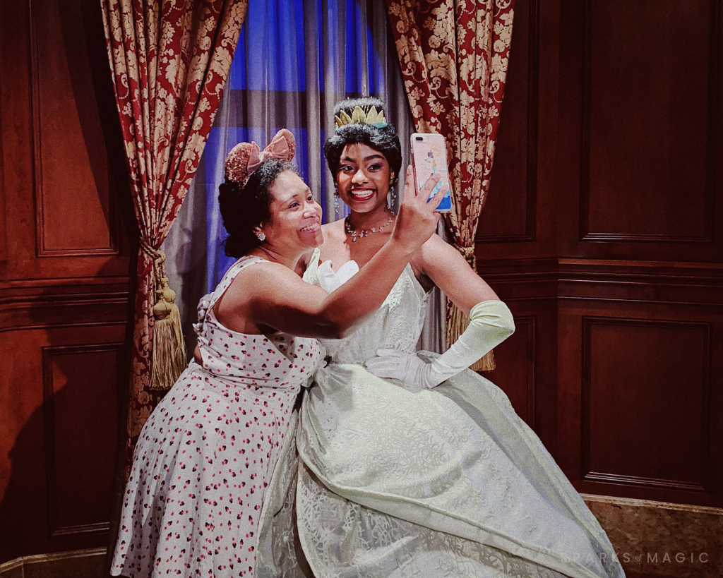 Black woman taking a selfie with Disney character Princess Tiana at Walt Disney World experiencing Part of the Disney Magic
