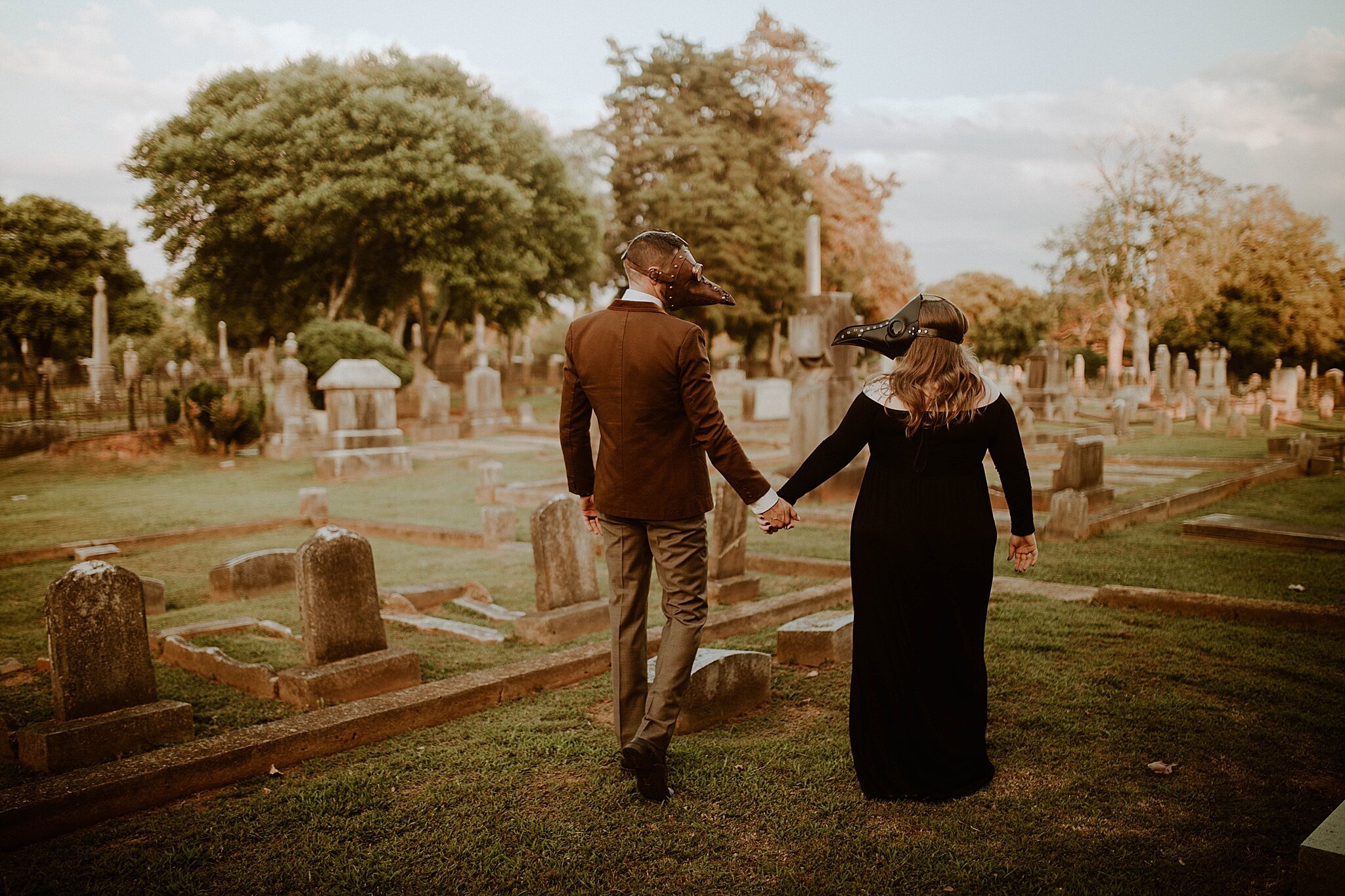 couple wearing plague masks walk through Florence AL graveyard