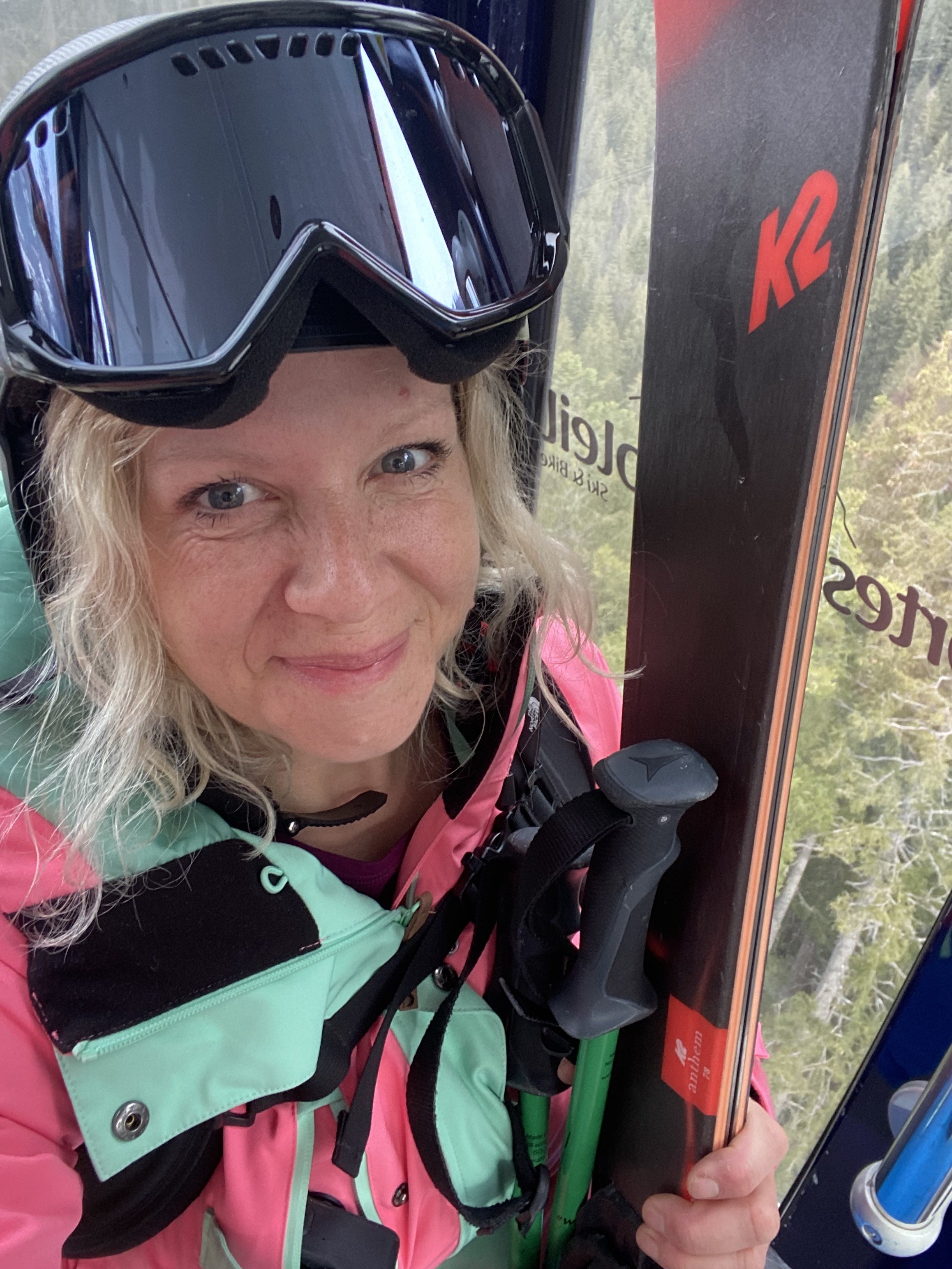Gail smiling in the Gondola up to Avoriaz holding skis in one hand