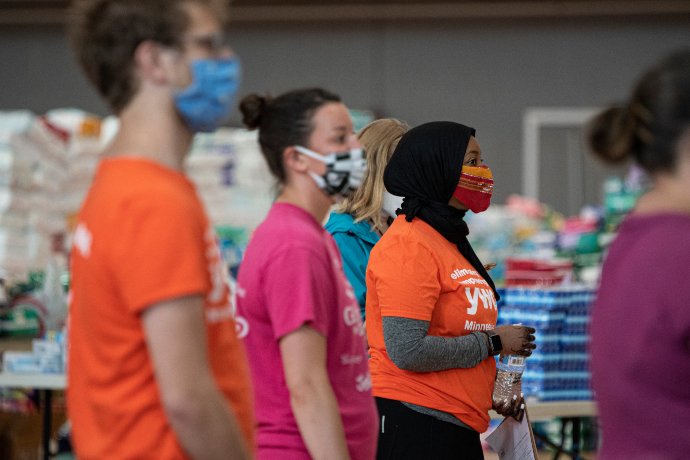 volunteers listen to safety and role instructions at YWCA distribution center