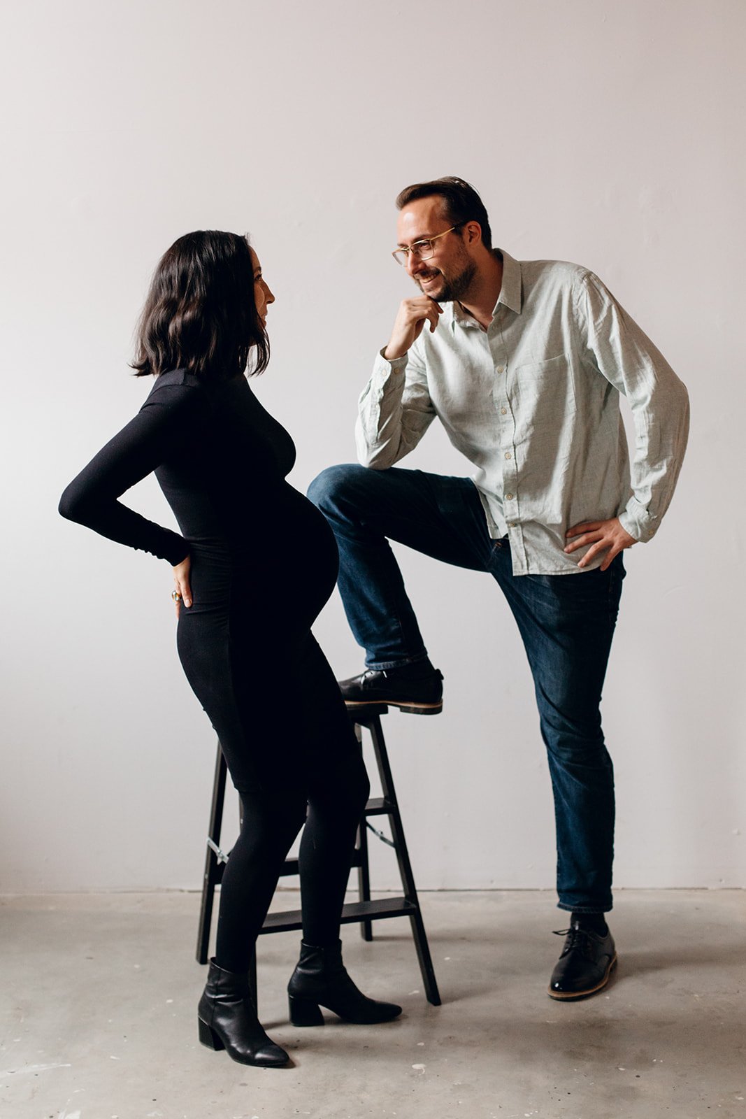 In-studio maternity photoshoot of couple.