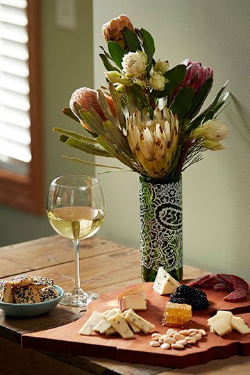 Re-purposing a Protea Wine Bottle into a vase to accompany the cheese tray!