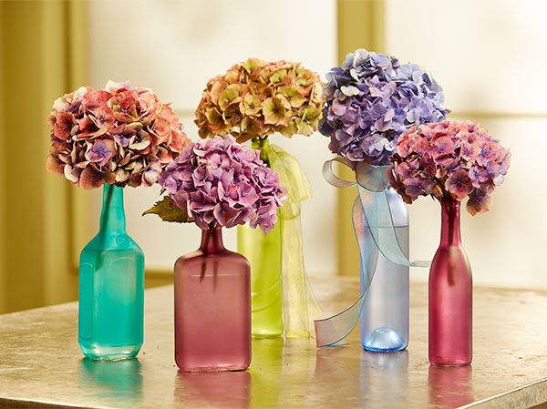 Transform any glass bottle in a Colorful Vase- add a bit of ribbon and one flower- VOILA!
