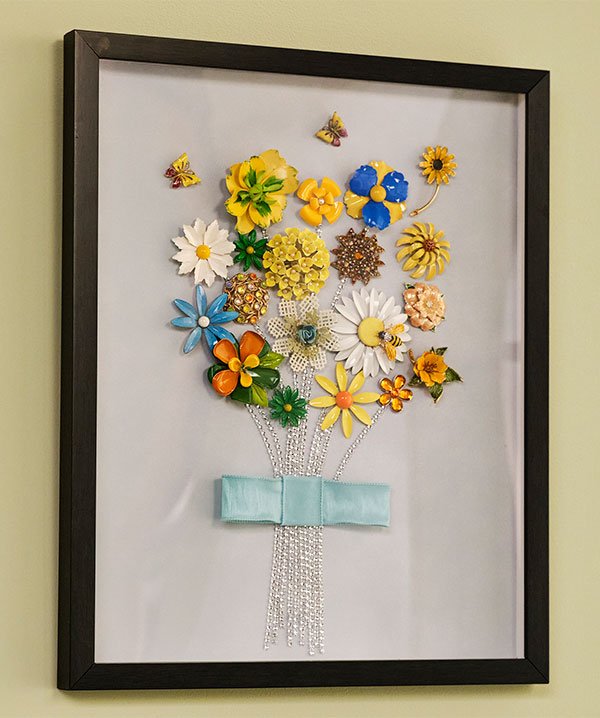 This is a super fun way to repurpose beautiful flower brooches- into a lovely work of art you can hang in your home!