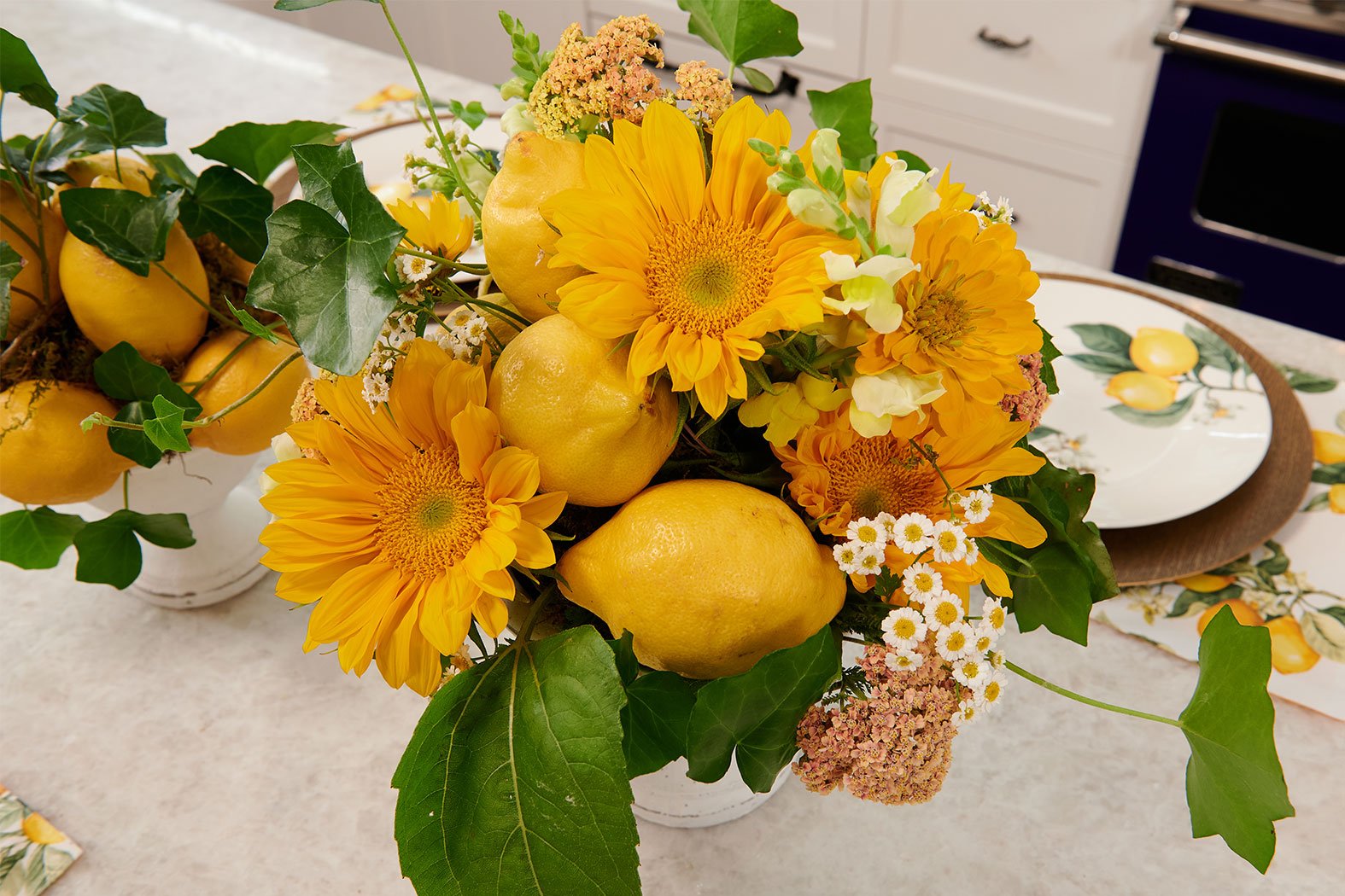 Flower Arrangements inspired by Italy- feature Sunflowers, Fresh Lemons, Chamomile, and Cottage yarrow- to complete this inspired table setting on “J Schwanke’s Life in Bloom”. 