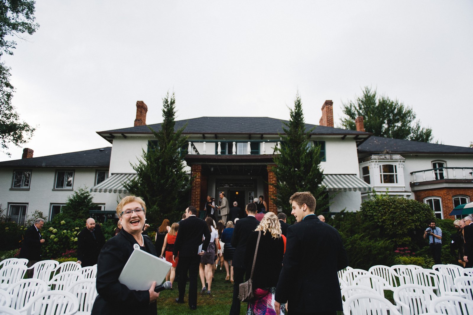 officiant still smiling as the rain comes down at the briars resort wedding of meg and tyson by toronto husband and wife wedding photography team jenn and dave stark