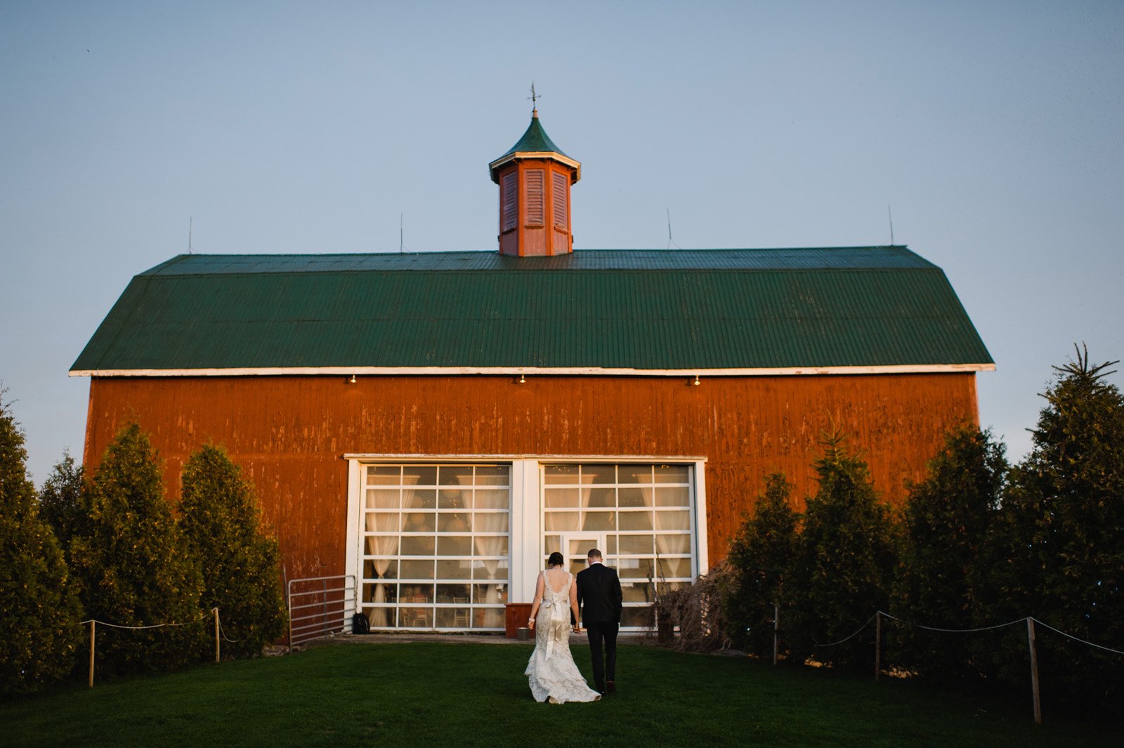 the big red barn at sunset during fields on west lake wedding of allison and matthew