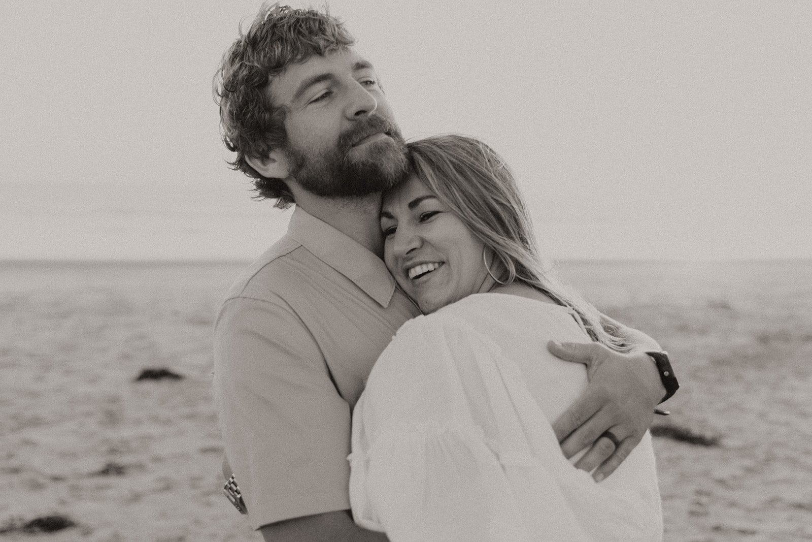 Black and white photo of couple hugging on the beach