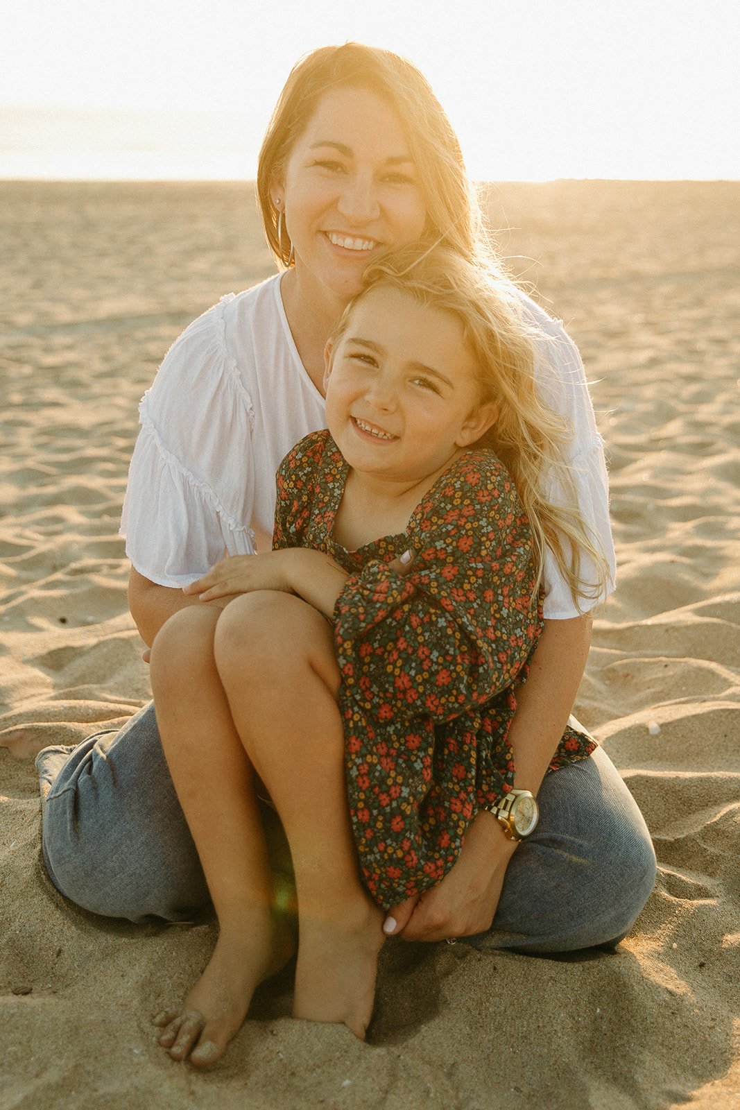 Mom and daughter smiling on the beach