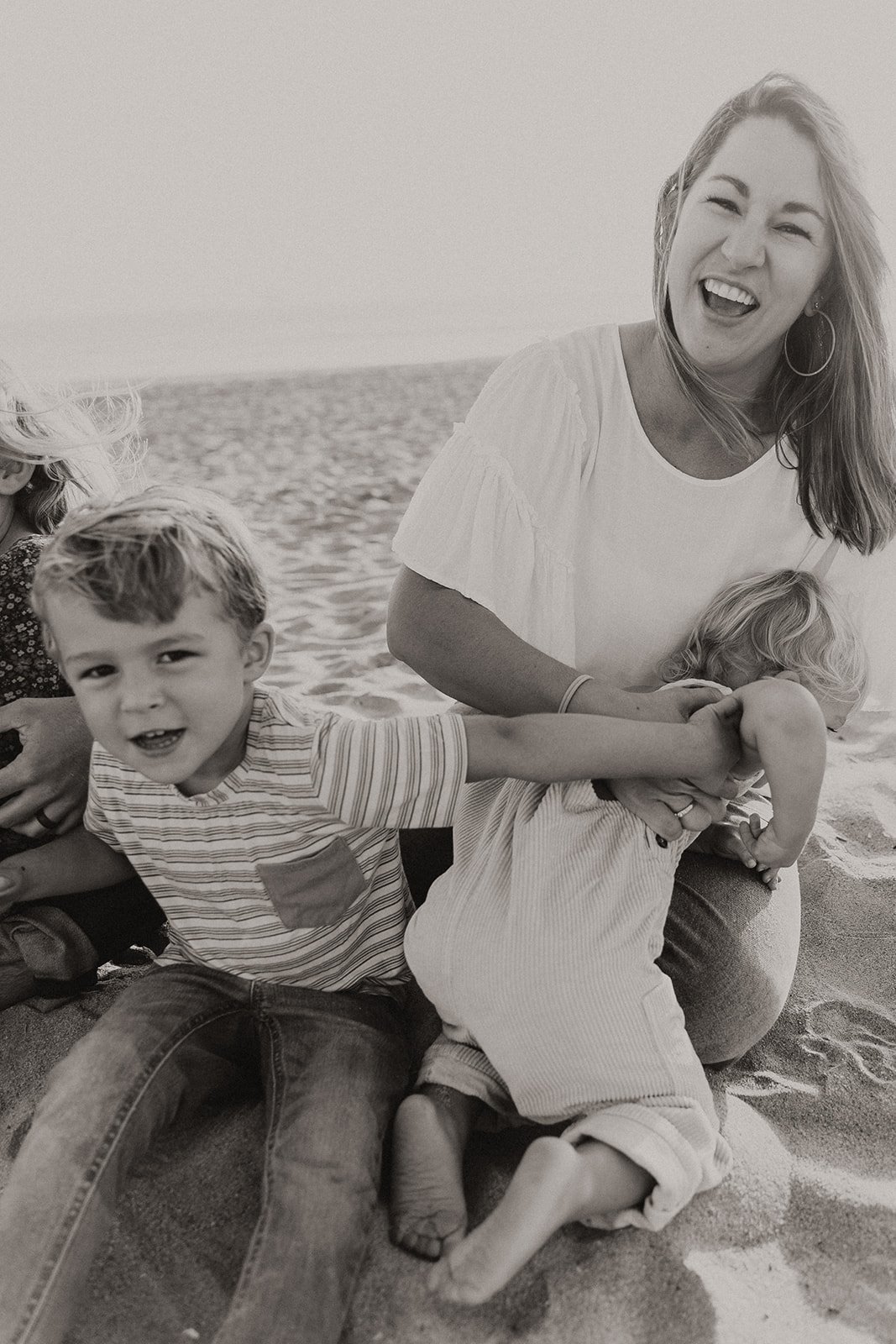 Black and white photo of mom and kids smiling and laughing