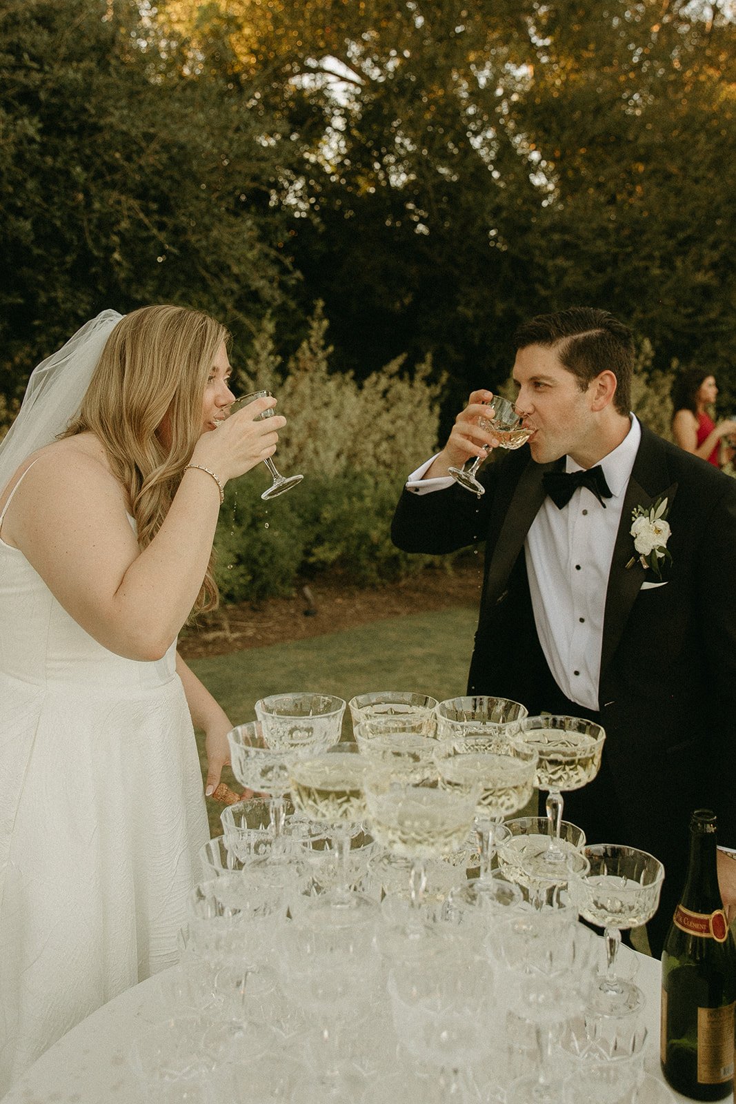 Bride and groom drinking from a champagne tower