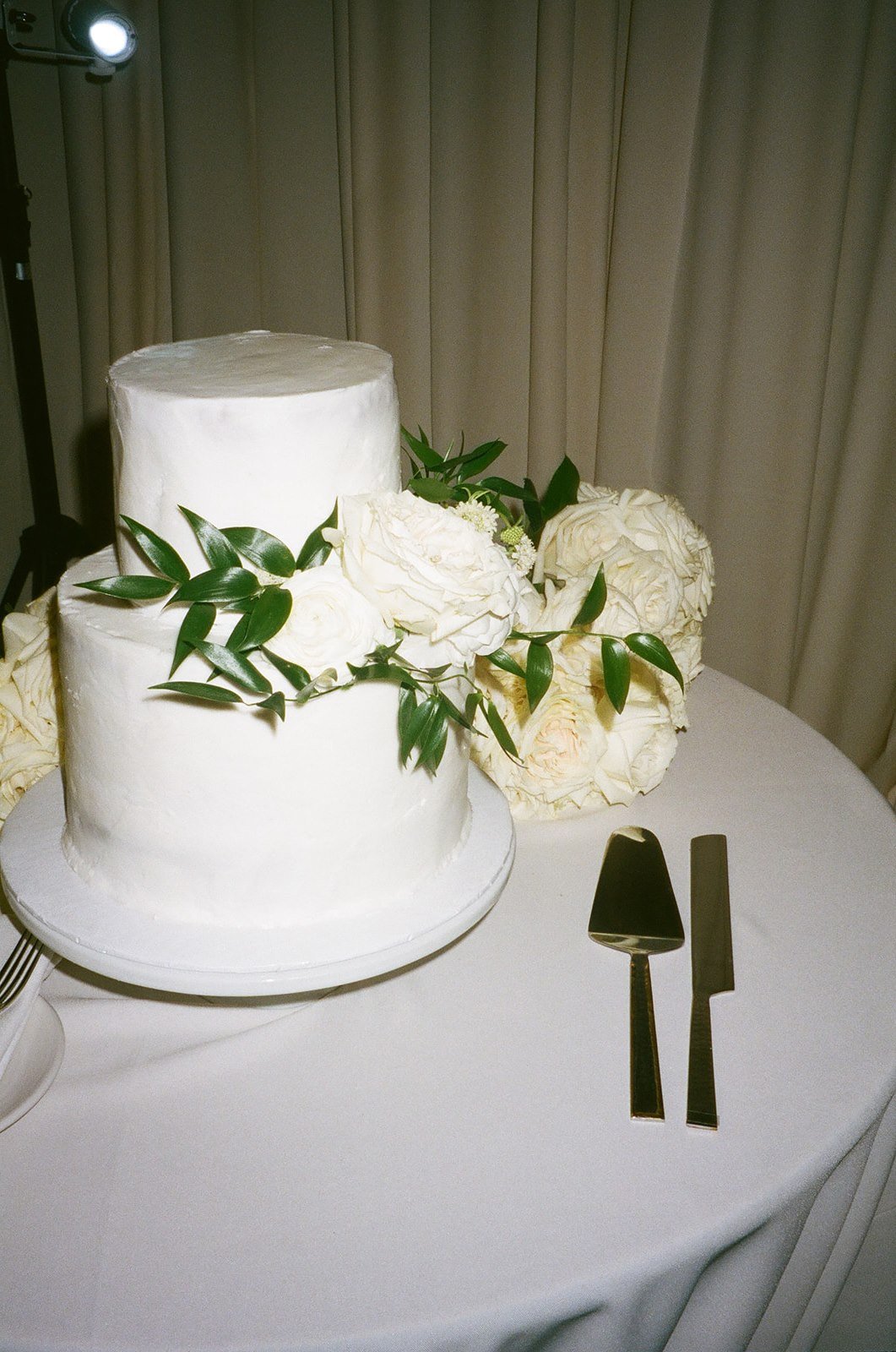 Beautiful white wedding cake with white florals on film
