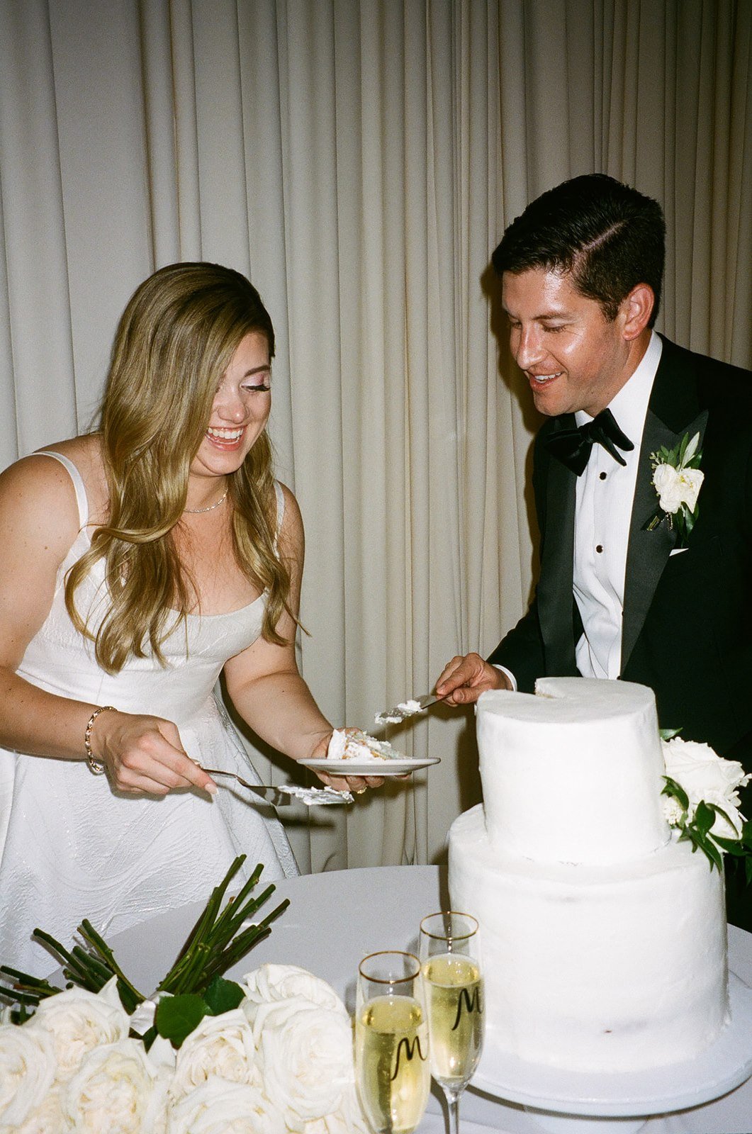 Bride and groom cutting wedding cake on film
