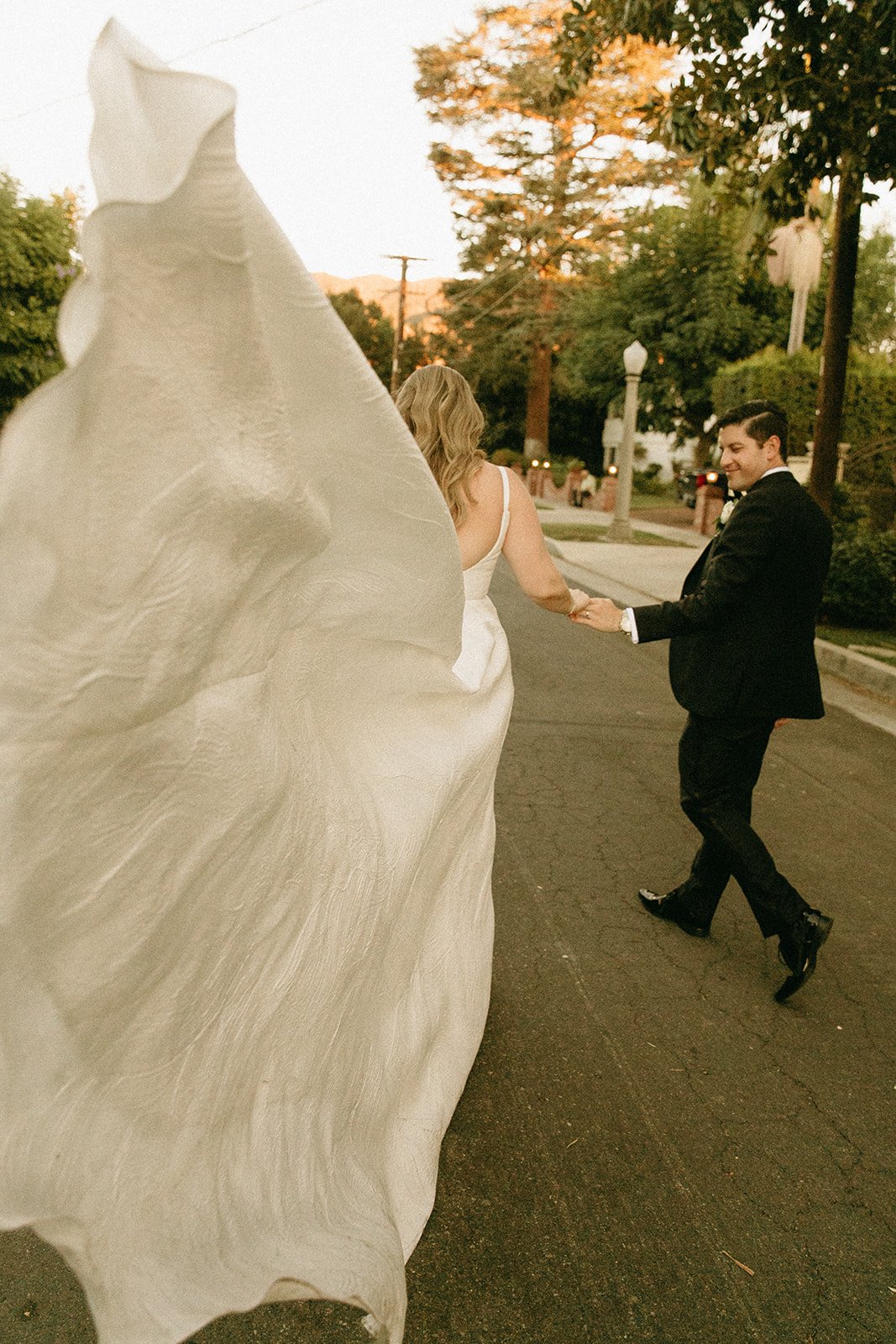 Bride and groom walking in the street holding hands
