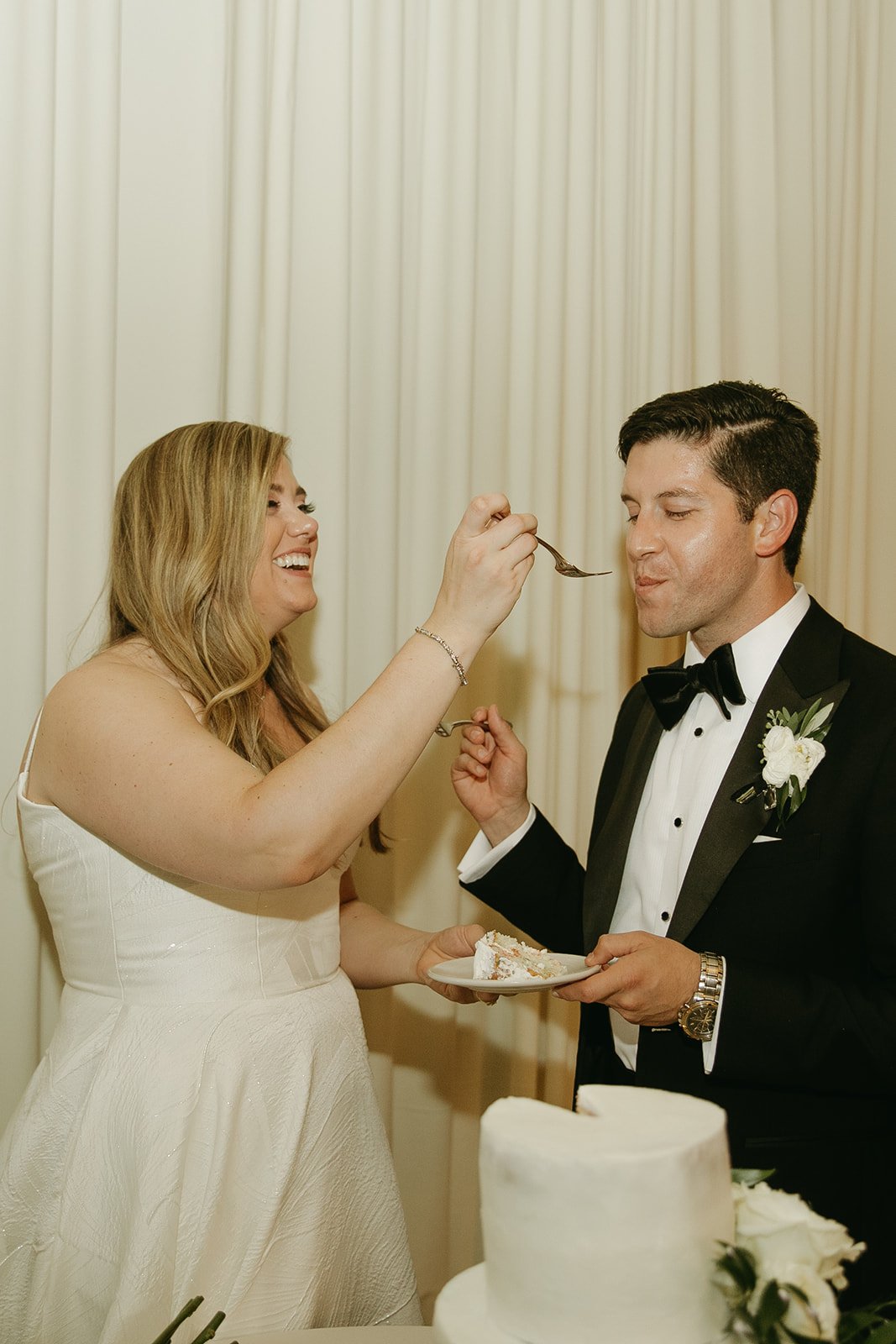 Bride and groom feeding eachother wedding cake
