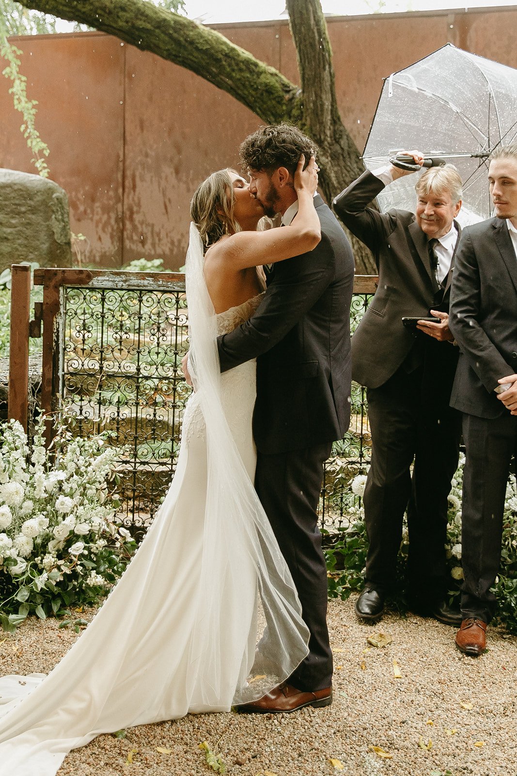Bride and groom kissing during outdoor wedding ceremony