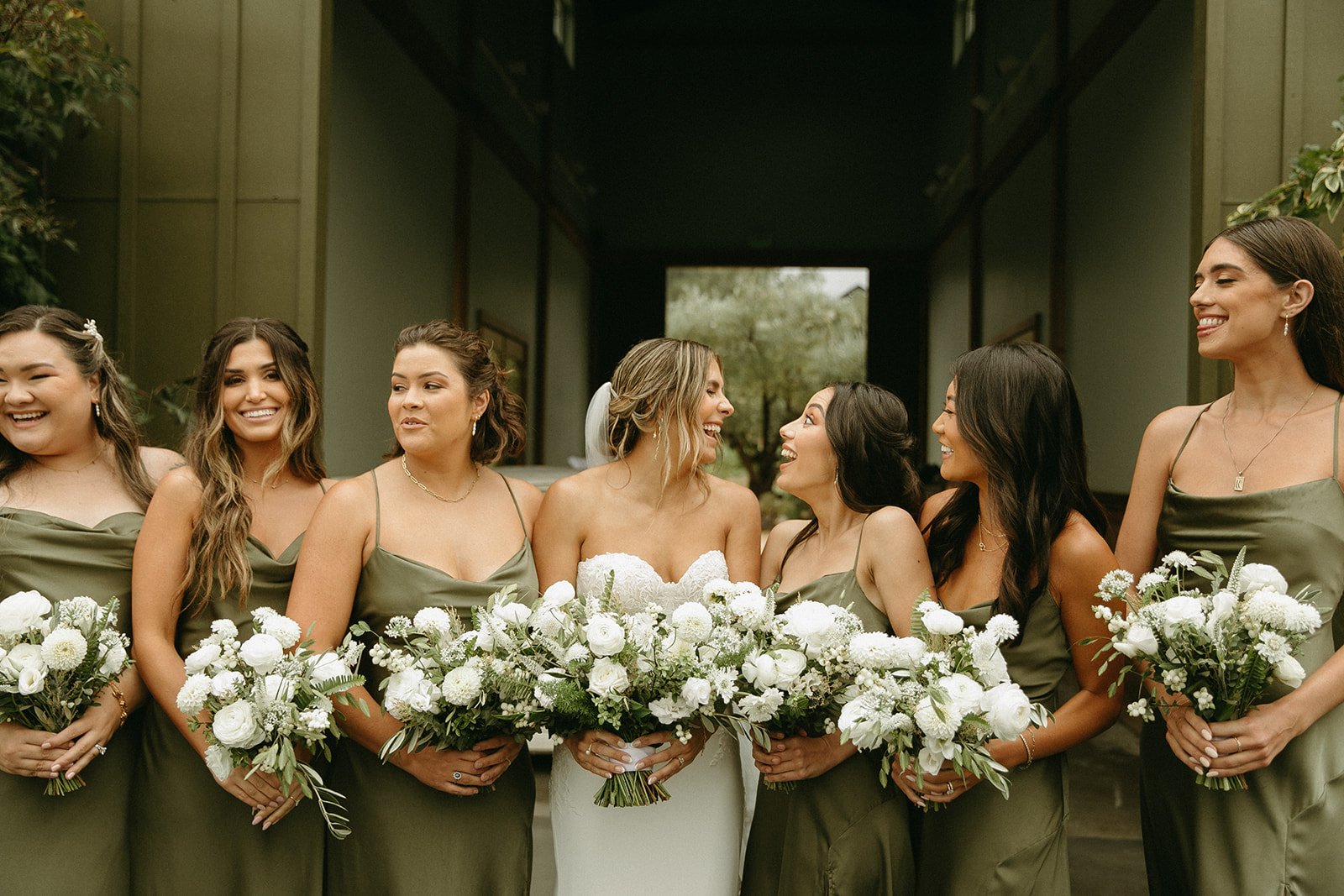 Bride and bridesmaids smiling and laughing