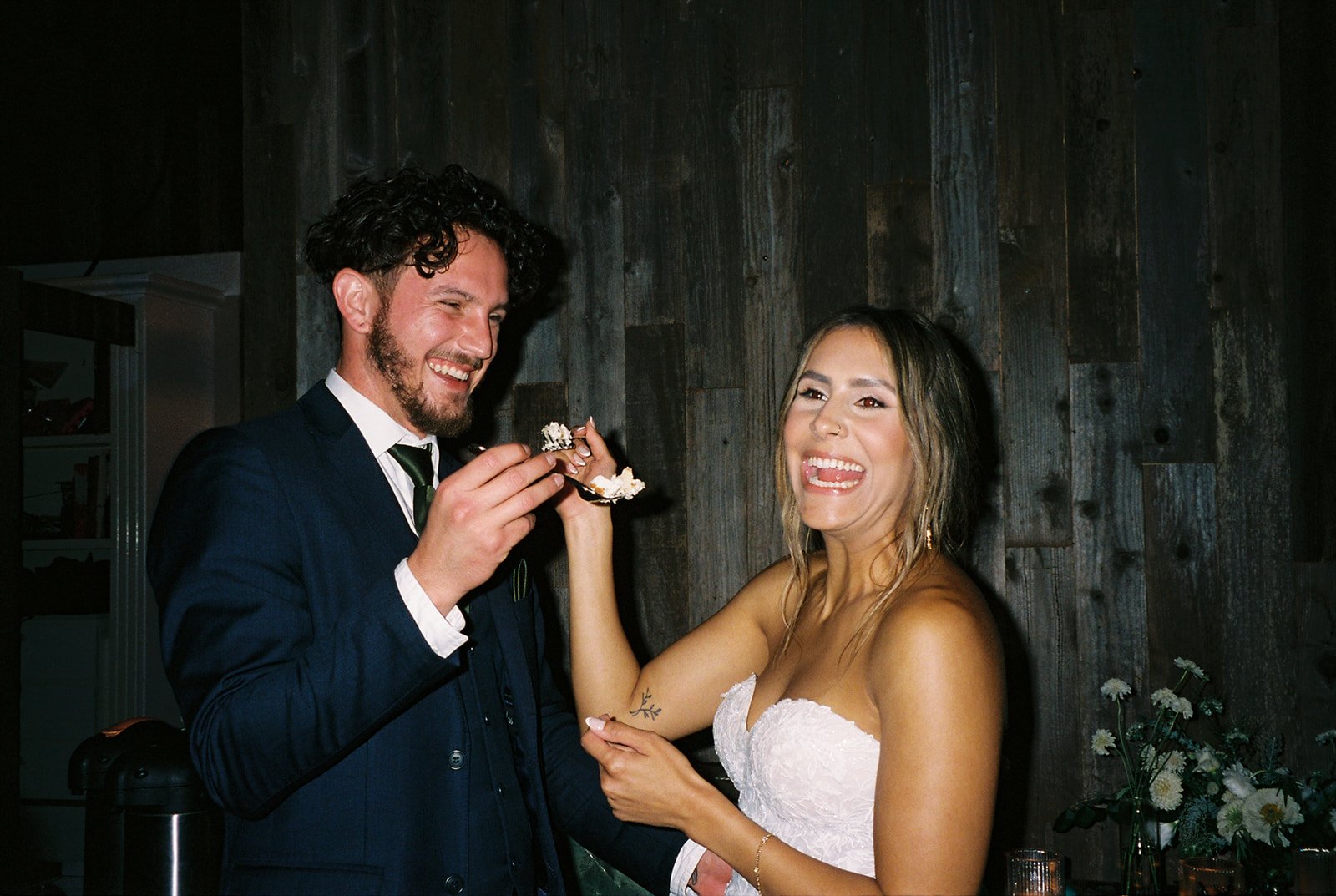 Film photos of bride and groom eating wedding cake