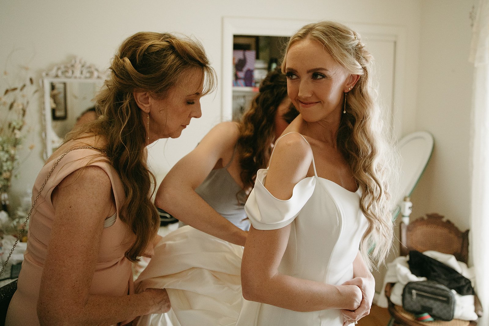 Bride getting ready while mom helps