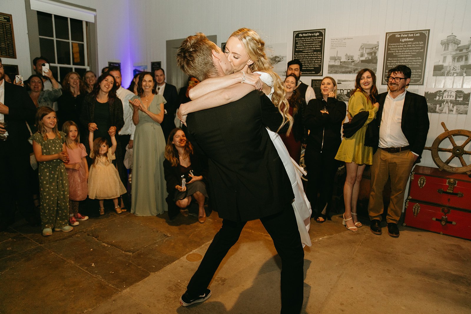 Bride and groom dancing and kissing on the dance floor during wedding reception