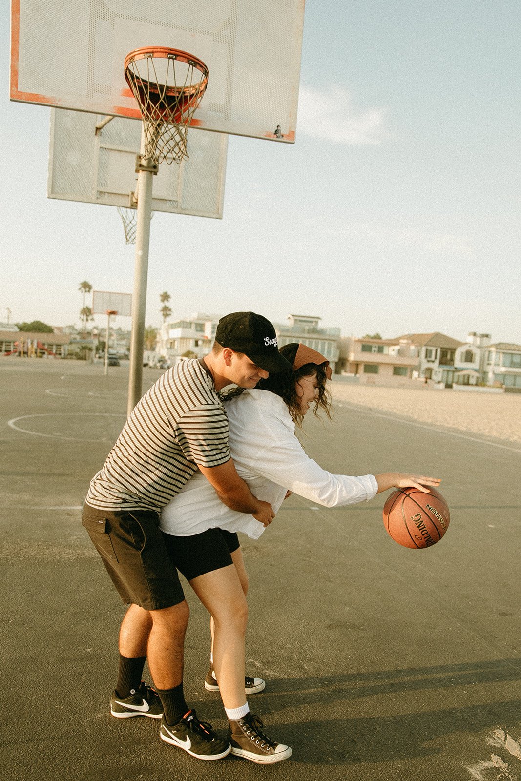 Newport Beach engagement photo session with couple at a basketball court