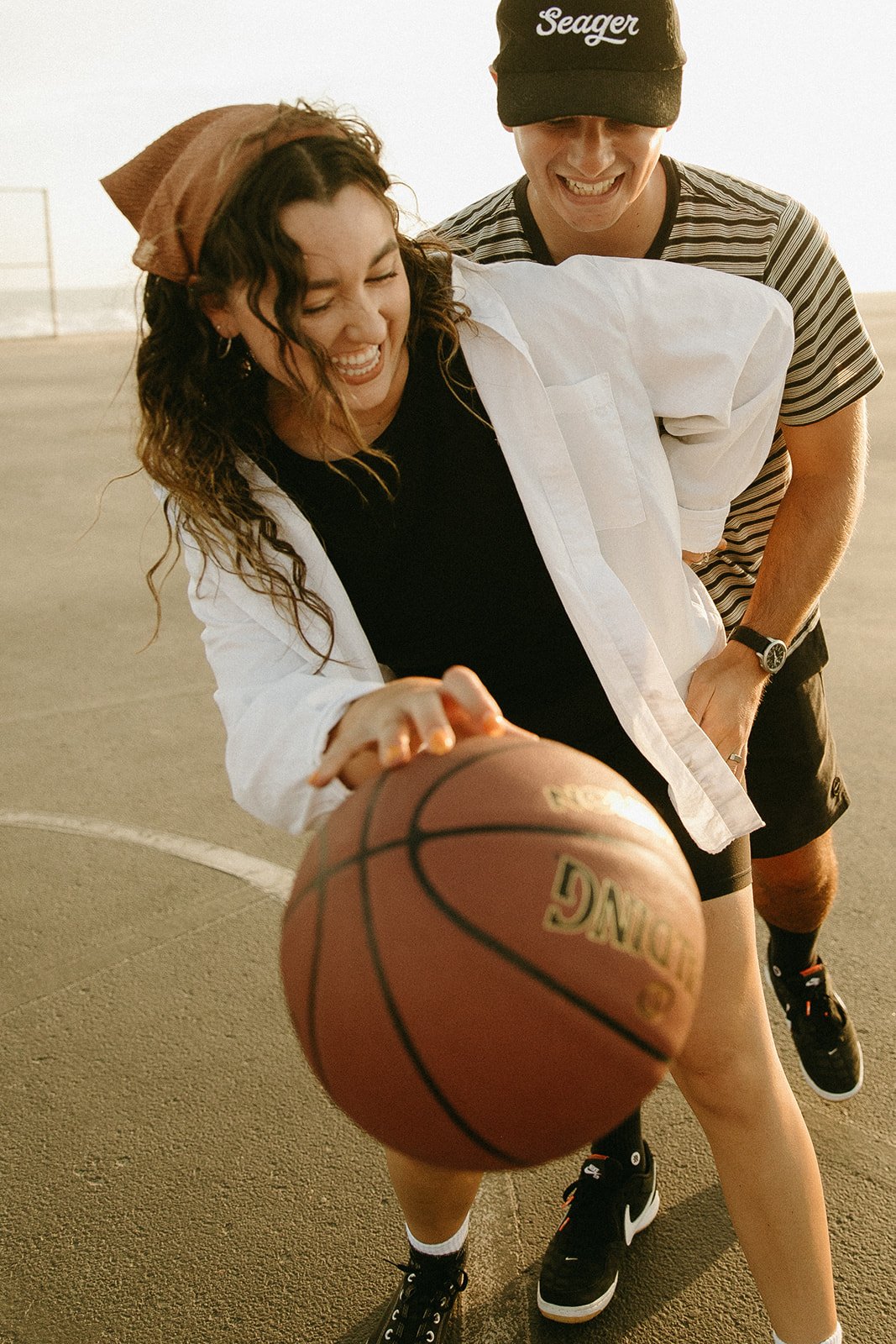 Newport Beach engagement photo session with couple at a basketball court playing basketball