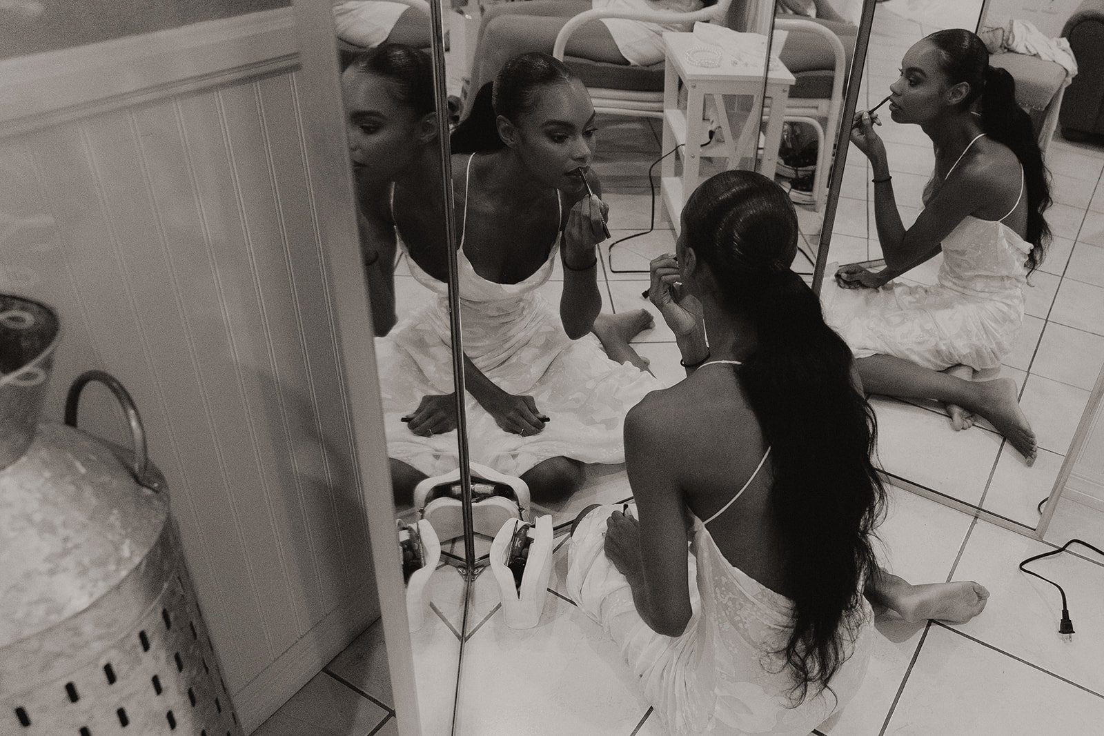 Black and white photo of bride getting ready in the mirror