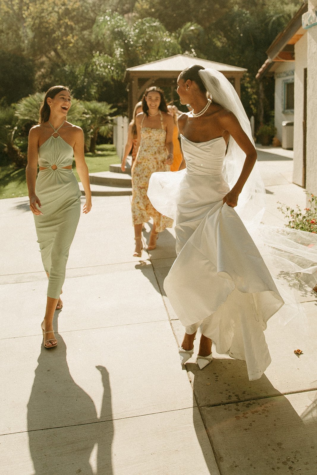 Bride and bridesmaids walking and laughing