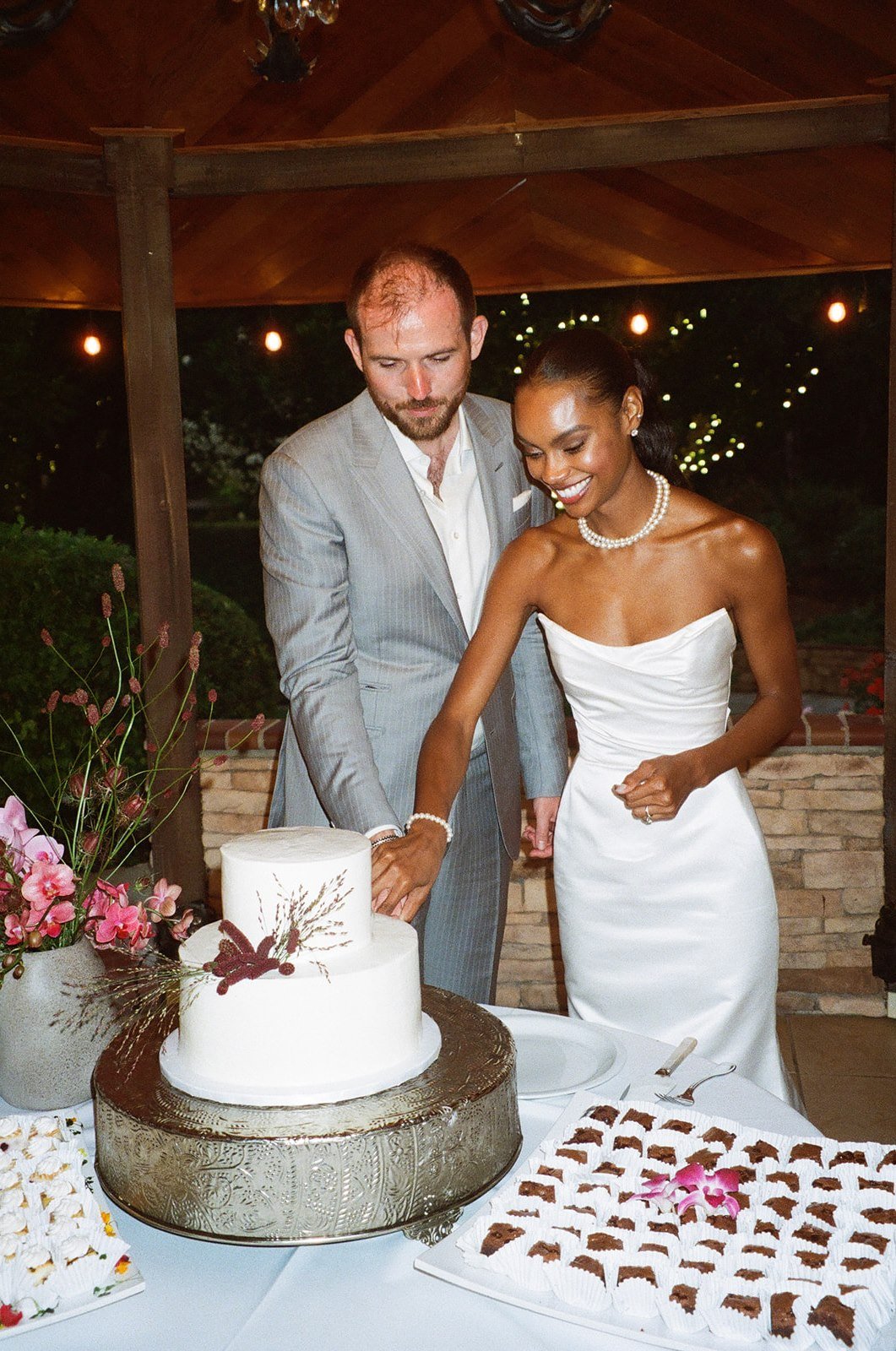 Film photo of bride and groom cutting wedding cake