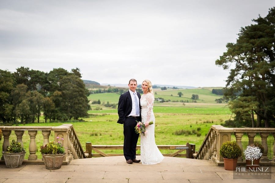 A couple portrait taking in the beautiful countryside behind at Woodhill Hall in Northumberland.