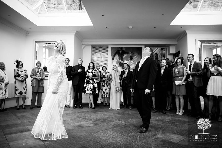 The bride and groom doing a funny dance in the Orangery during their Woodhill Hall wedding.