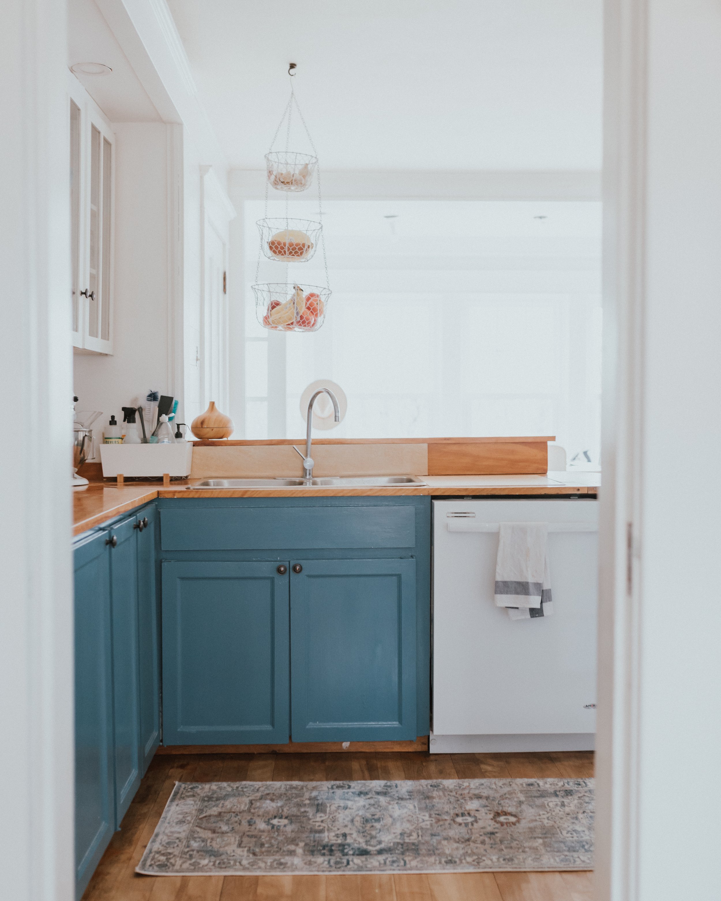 The Wild Decoelis | How We Transformed Our Kitchen For Under $1500 | after | blue kitchen cabinets in Behr Blueprint