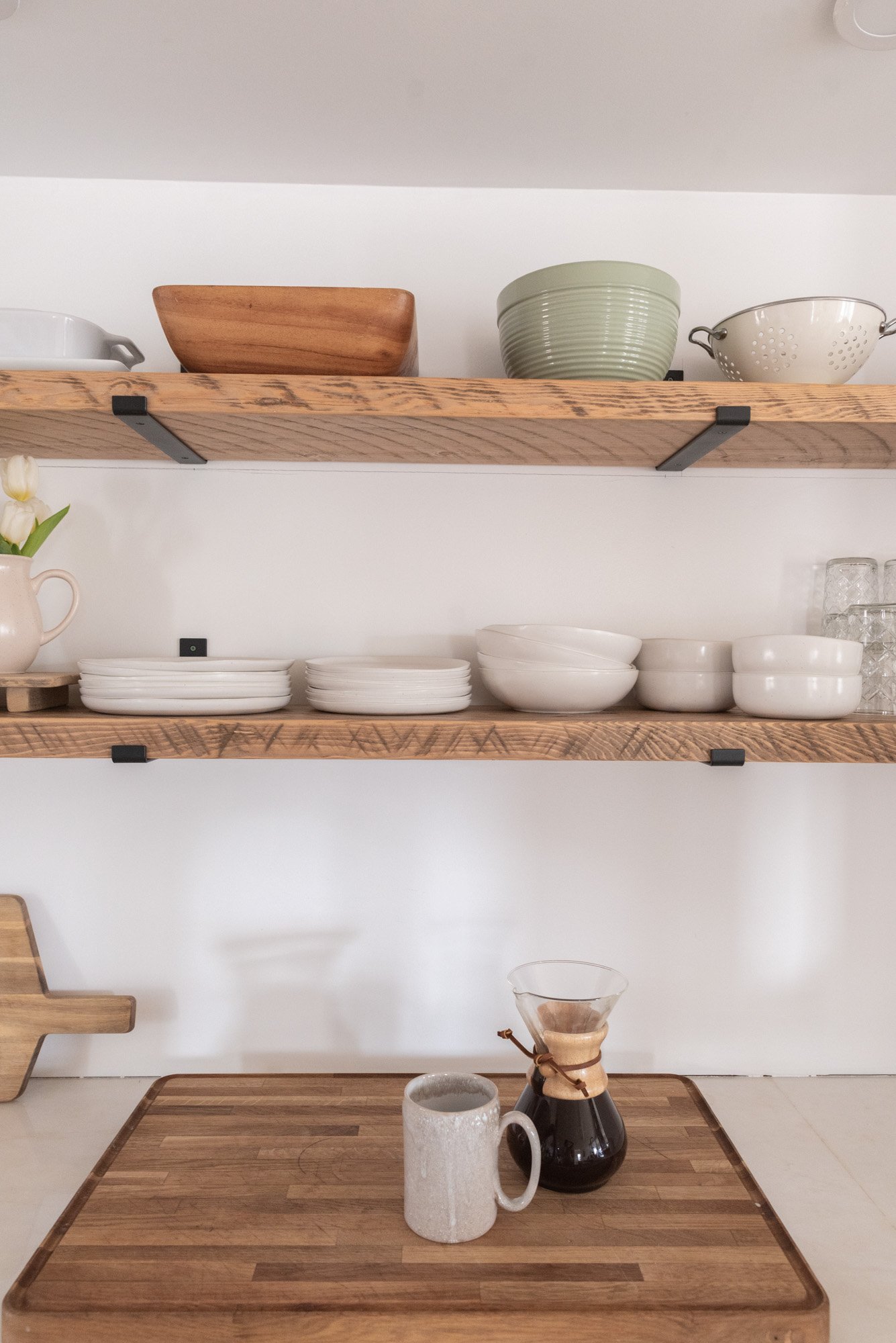 The Wild Decoelis | Kitchen shelves rough sawn with black iron brackets minimal reclaimed wood and white ceramics.