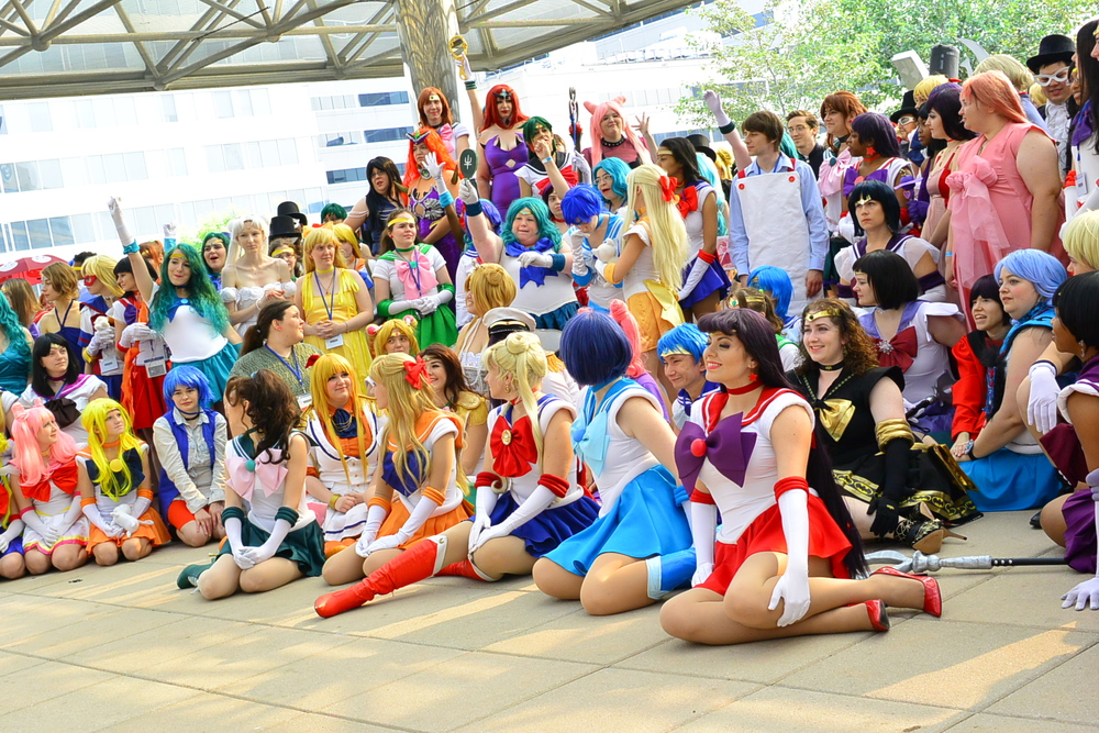 A crowd of Sailor Moon cosplayers gather for a large photo