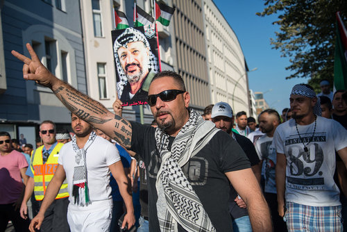 An anti-Semitic protester in Berlin with a pro-Nazi tattoo on his arm. Credit: Wikimedia Commons. 