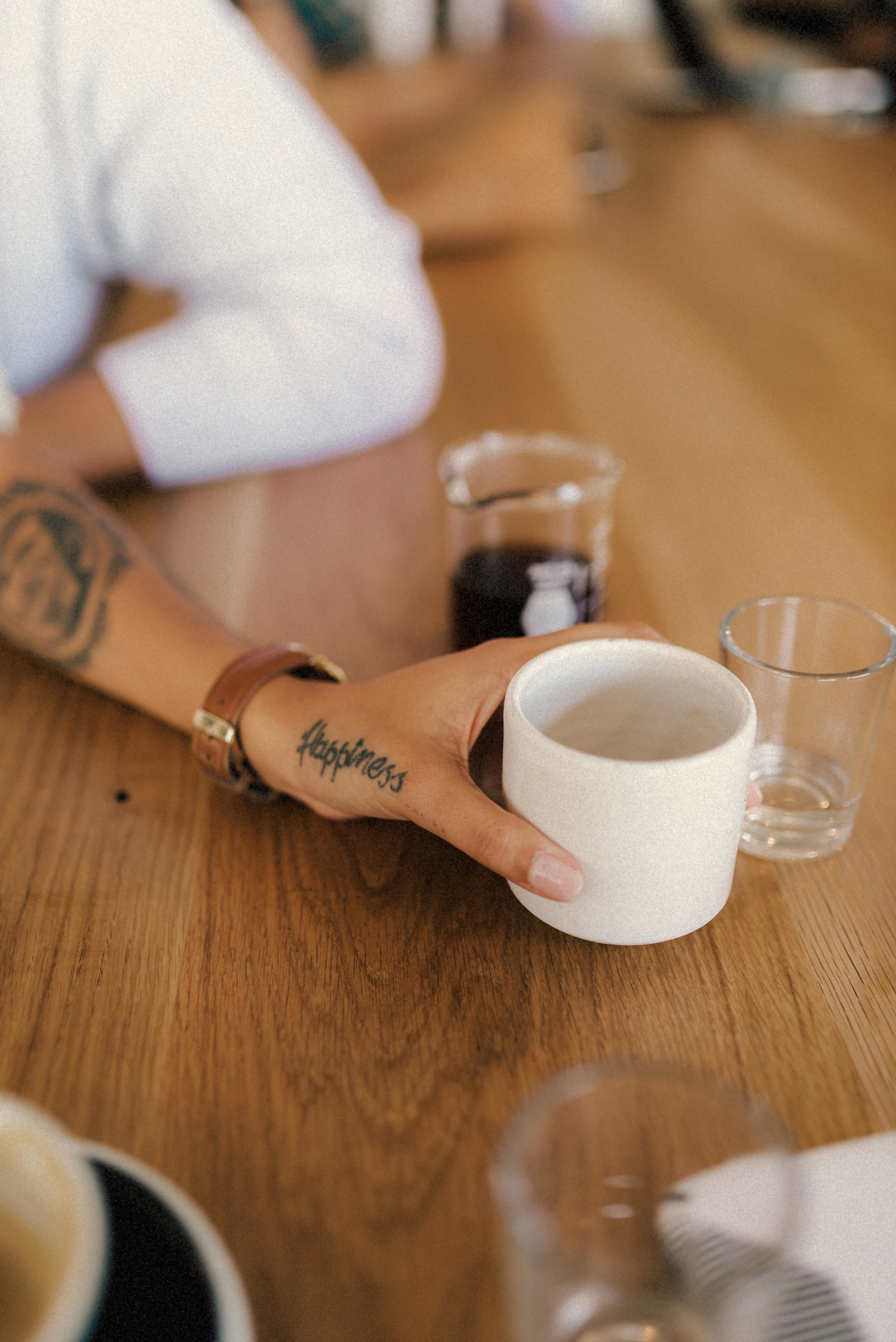 a tattoo on Hillary's hand as she reaches for her coffee - Bandit Coffee - St Pete Florida - Naples Florida Wedding Photographer - Tampa Wedding Photographer