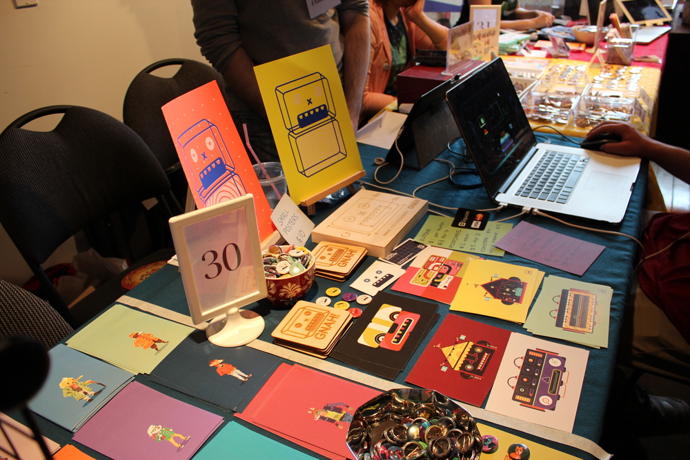 Some wares, images, zines, and postcards for sale at the Bit Bazaar.