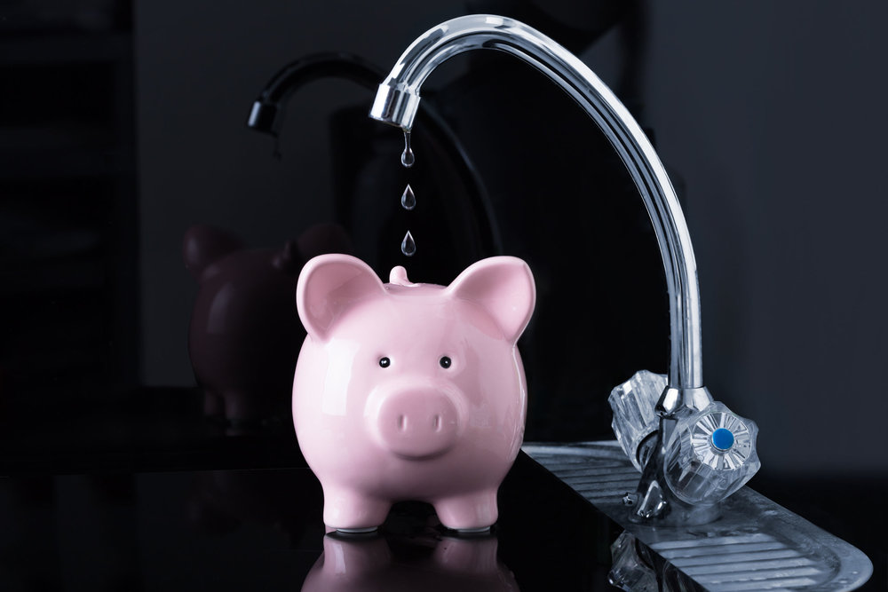  94716985 - dripping water droplets are falling in the pink piggybank from kitchen sink faucet 
