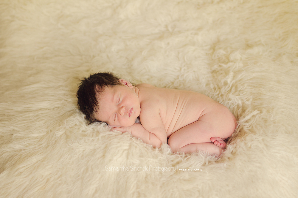 baby girl sleeps on a natural flokati rug during a cincinnati newborn photographer session