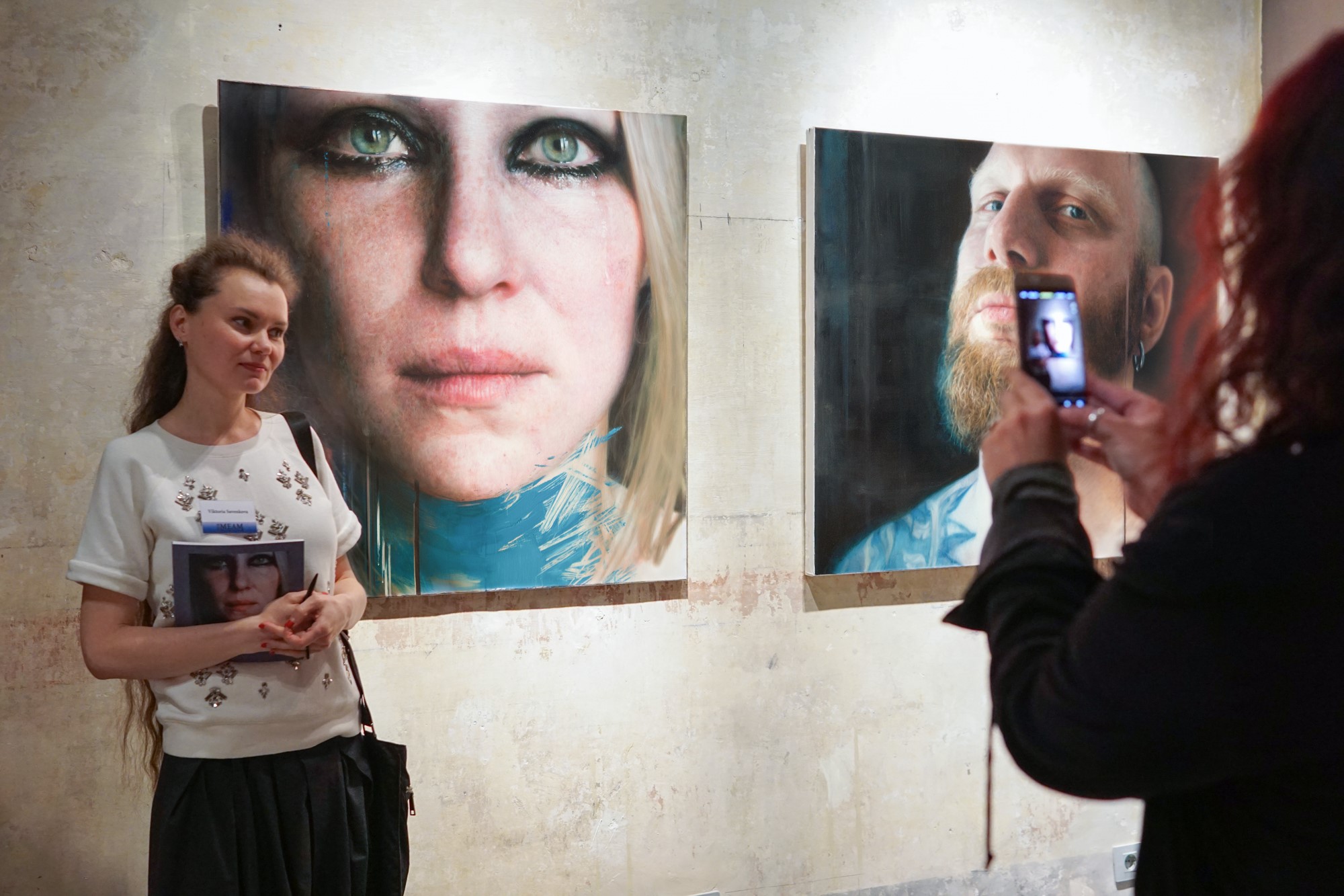 Viktoria Savenkova next to her paintings  Blue 1  (left) and  Ales  (right)