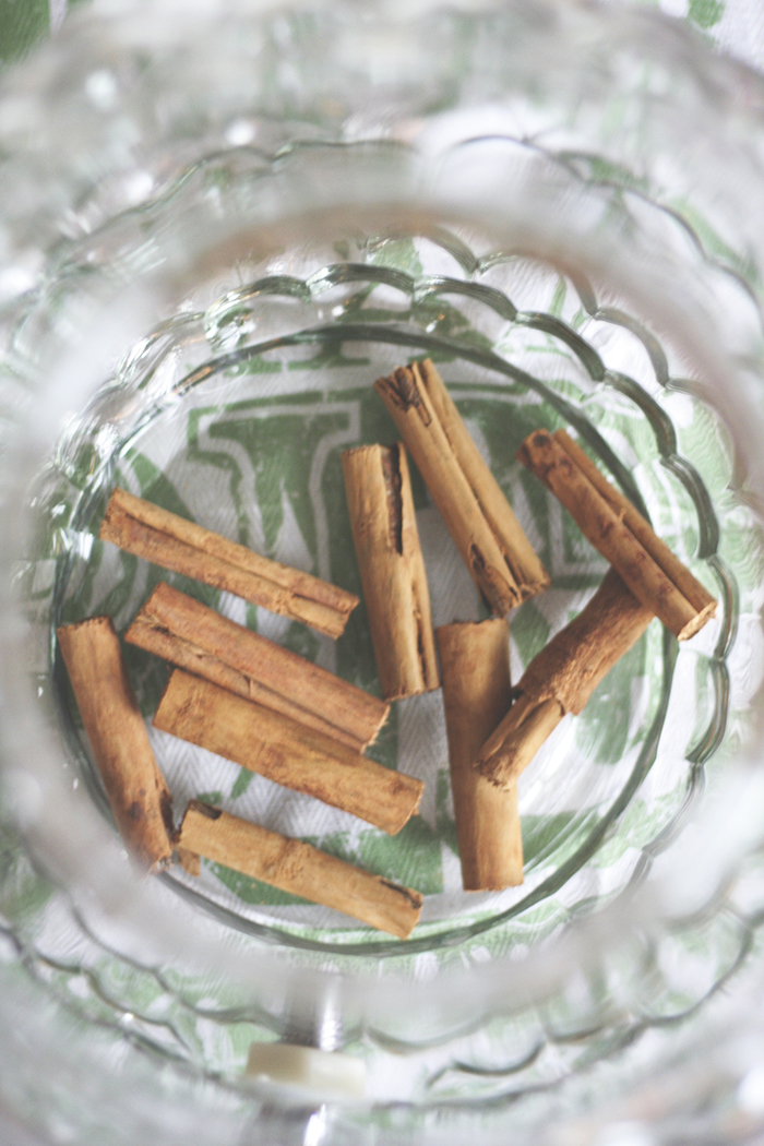 Use a large glass container to hold your whiskey. Something along the lines of a large punch bowl will work perfectly. Drop a handful of cinnamon sticks into the bowl. 