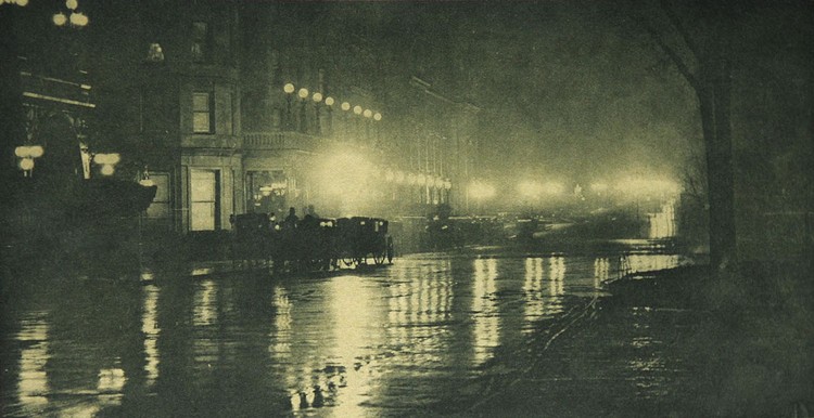 Alfred Stieglitz, The Glow of Night — New York, Photogravure: Multiple Color, 1897.  Photographed in 1897 Manhattan, this nighttime view shows the Savoy Hotel with a queue of carriages along a rain-slicked Fifth Ave. The nighttime “glow” effect in this plate is achieved in the printing process.