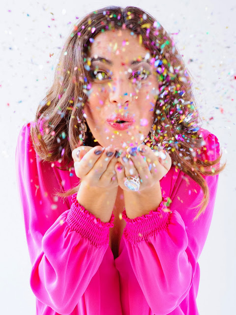 girl blowing confettit fashion editorial glitter christmas ootd pink