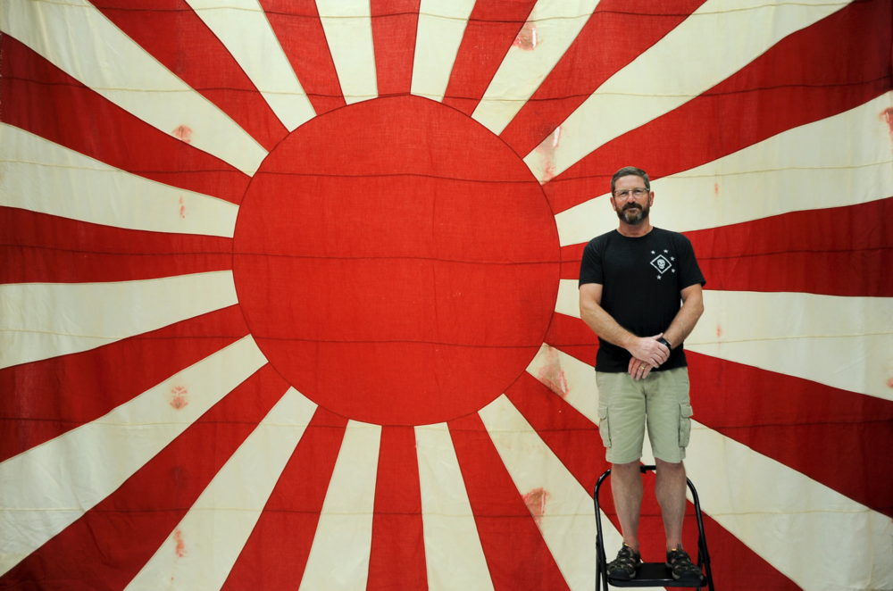 Bill Koehler, president of US Marine Raider Association, and a Japanese flag he is taking back to Japan.
