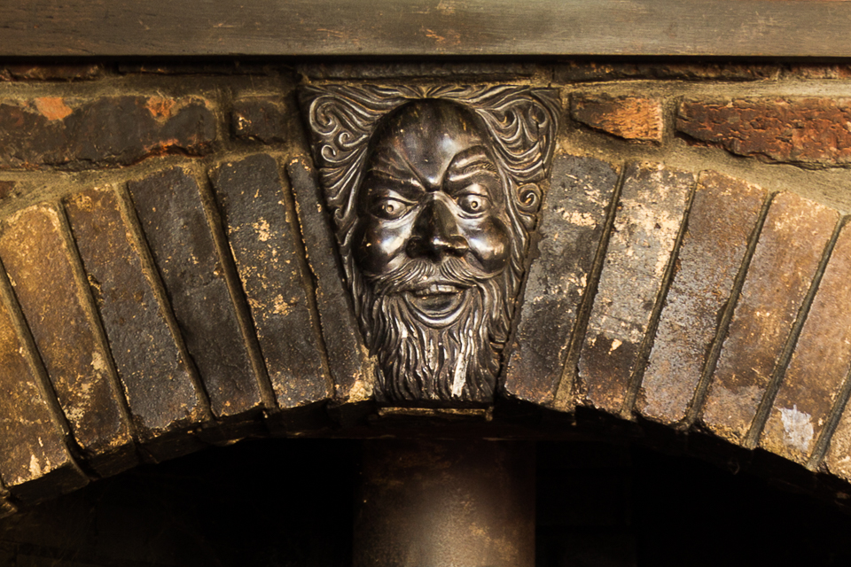 Earth House bronze fireplace detail. Gee, that face looks familiar.