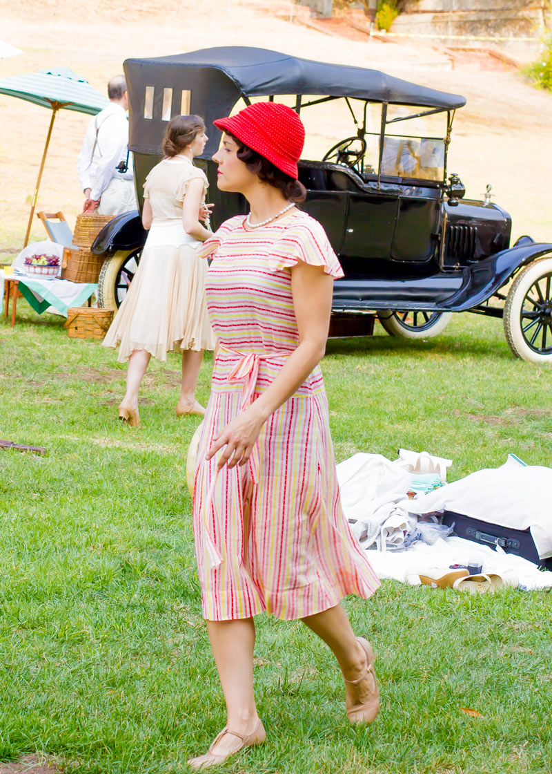  This dress is very similar to the one above, but you can see the influence of the 1930s look in the frilly cap sleeves and the slender ribbon at her natural waist. 